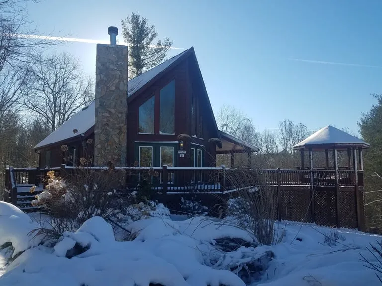 Lazy Deer Cabin with its deck and gazebo in a quiet winter landscape