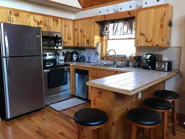 Wooden kitchen with stainless appliances and island seating