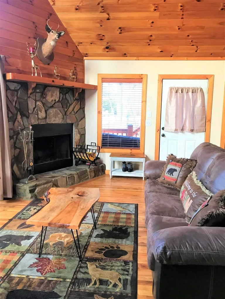 Rustic living room with leather seating and a stone fireplace