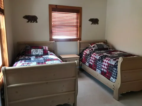 Twin beds in a wood-accented cabin bedroom